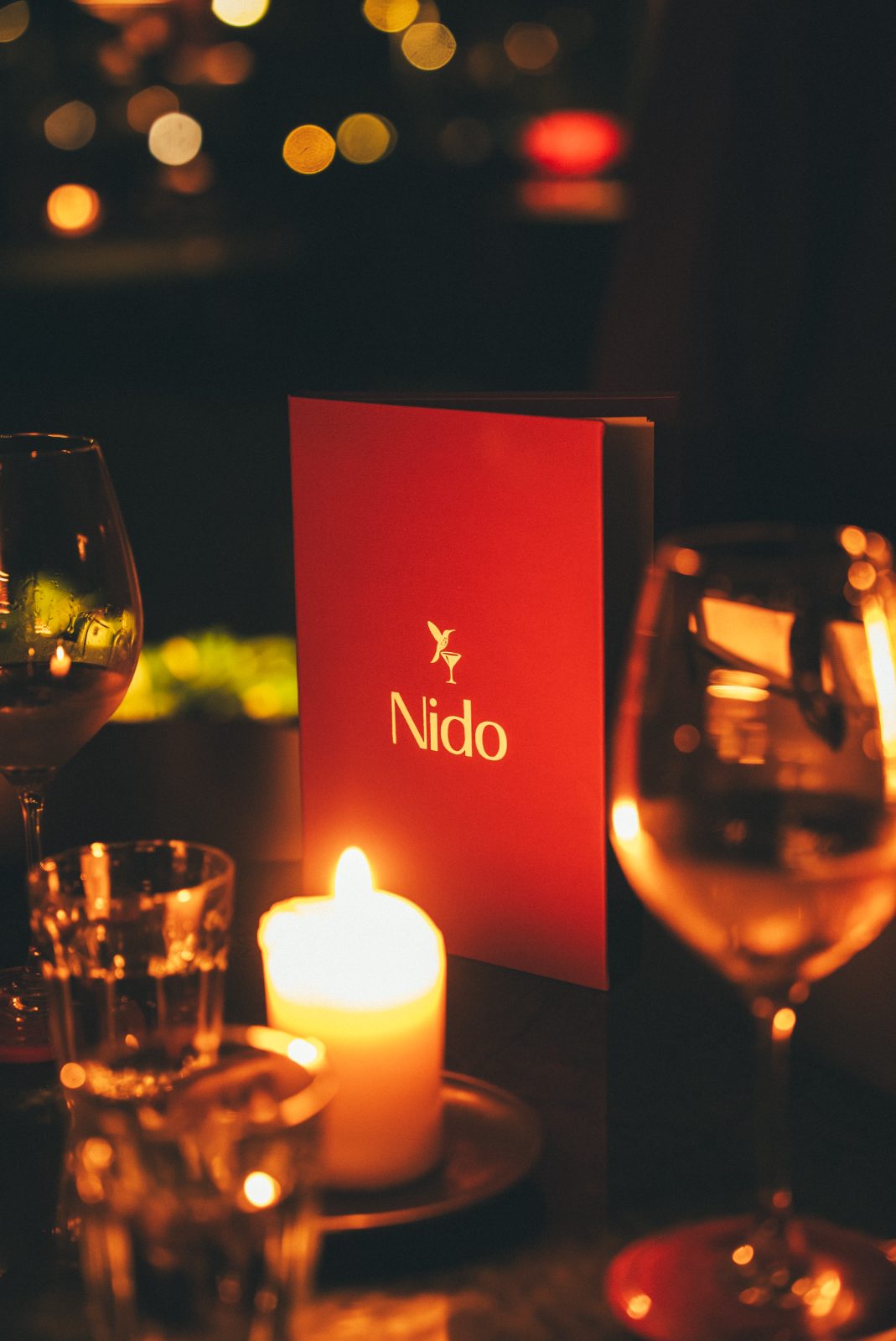 De rode menukaart van Nido bij kaarslicht